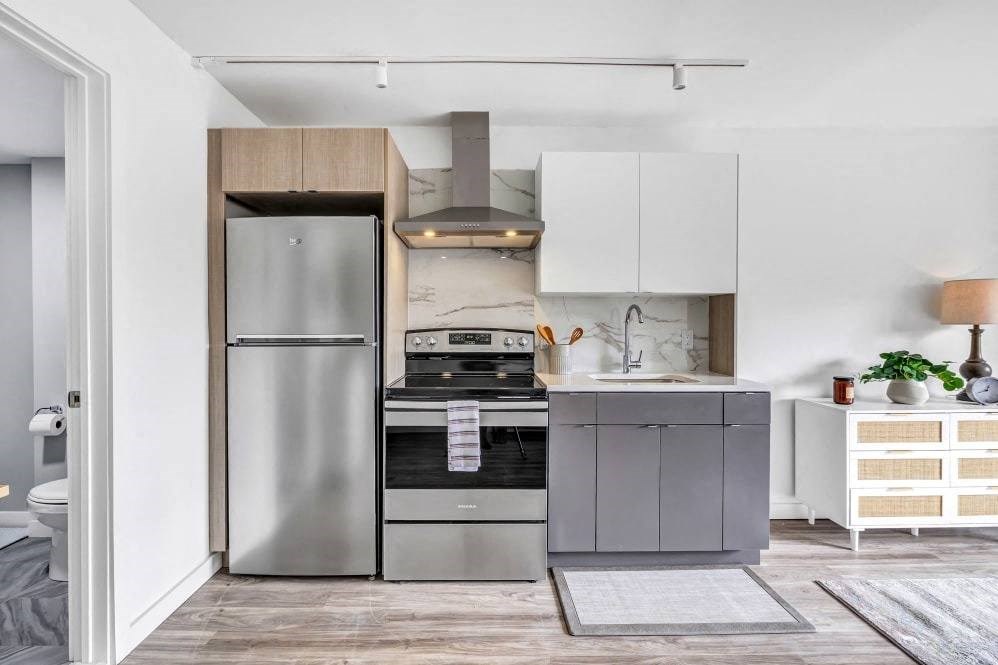 a small kitchen with stainless steel appliances and white cabinets