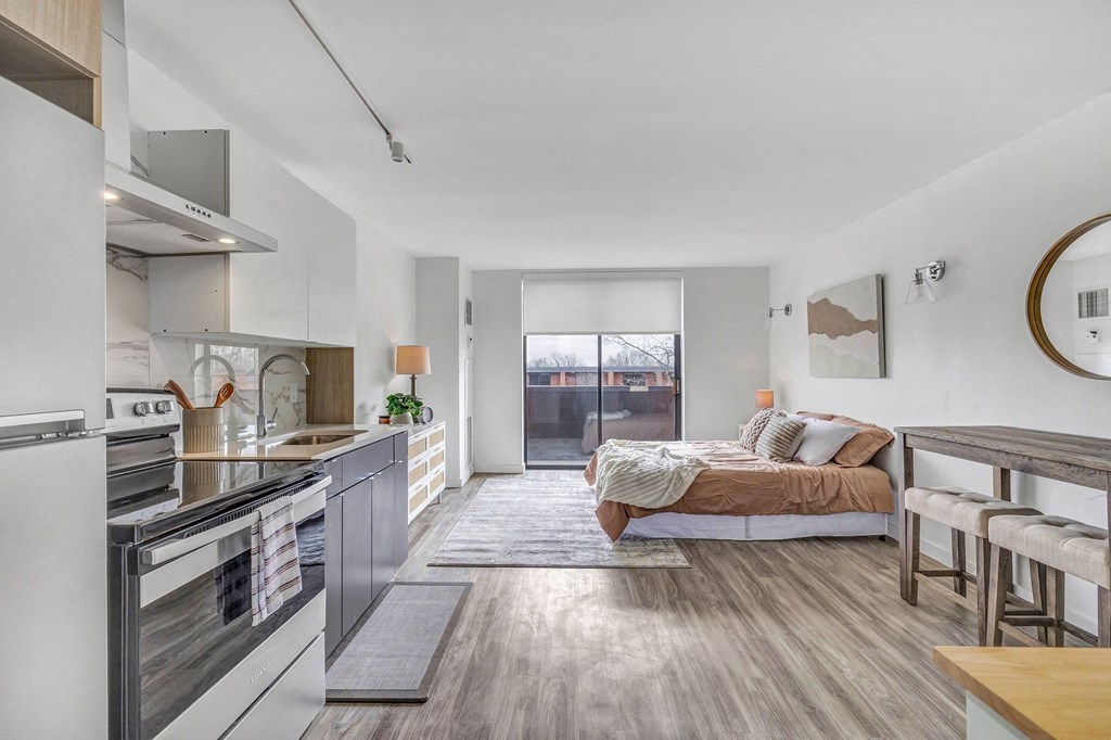 a living room with a couch and a kitchen with a stove and a sink