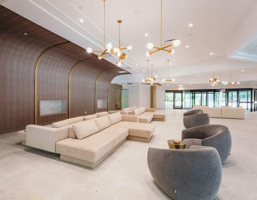 a lobby with couches and chairs and chandeliers