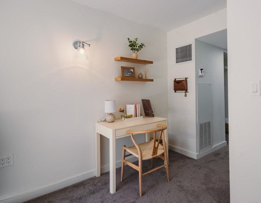 a desk with a chair and a mirror in a room