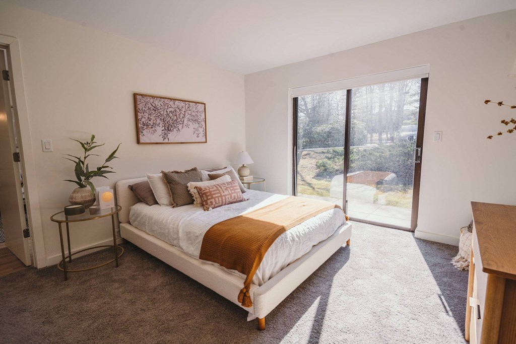 a bedroom with a bed and a sliding glass door