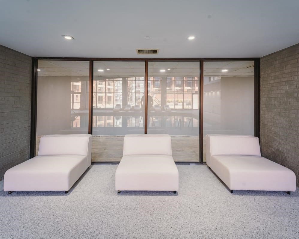 a room filled with white couches and a window