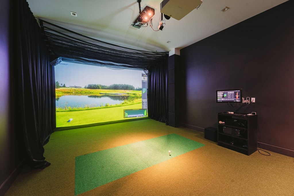 a room with a view of a golf course and a projector screen on the wall