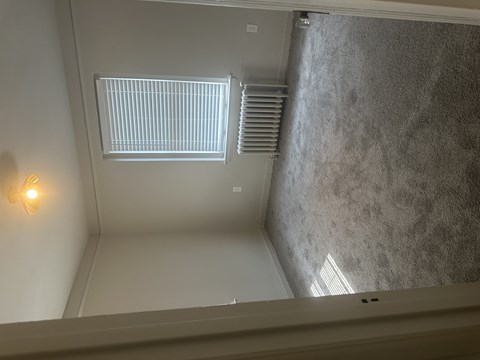 A bathroom with a shower and a window.