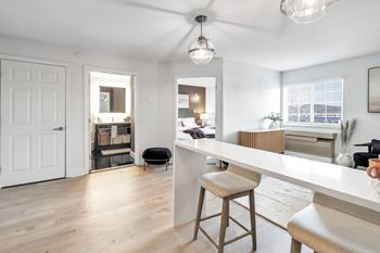 an open kitchen and living room with a white counter top at The Meriden, 06450