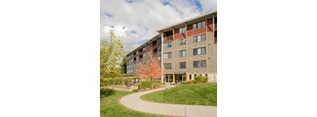 A large apartment building with a walkway in front of it.