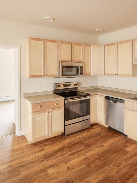 A kitchen with wooden cabinets and a stove top oven.