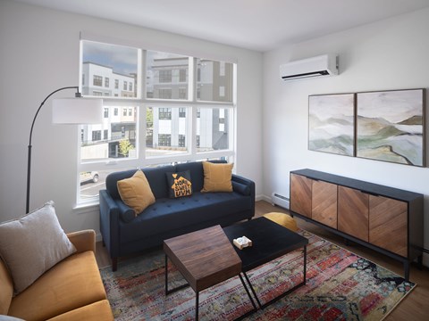 A living room with a blue couch and a wooden coffee table.