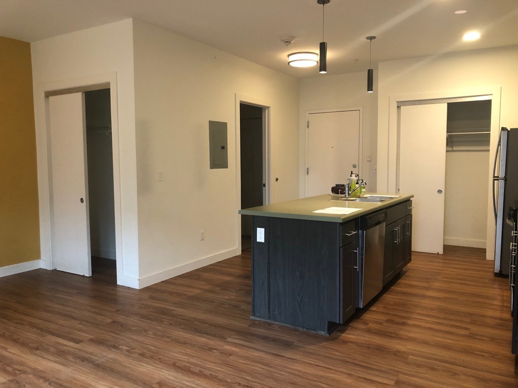 A kitchen with a black counter top and cabinets.