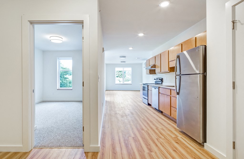 a renovated kitchen with stainless steel appliances and wood flooring
