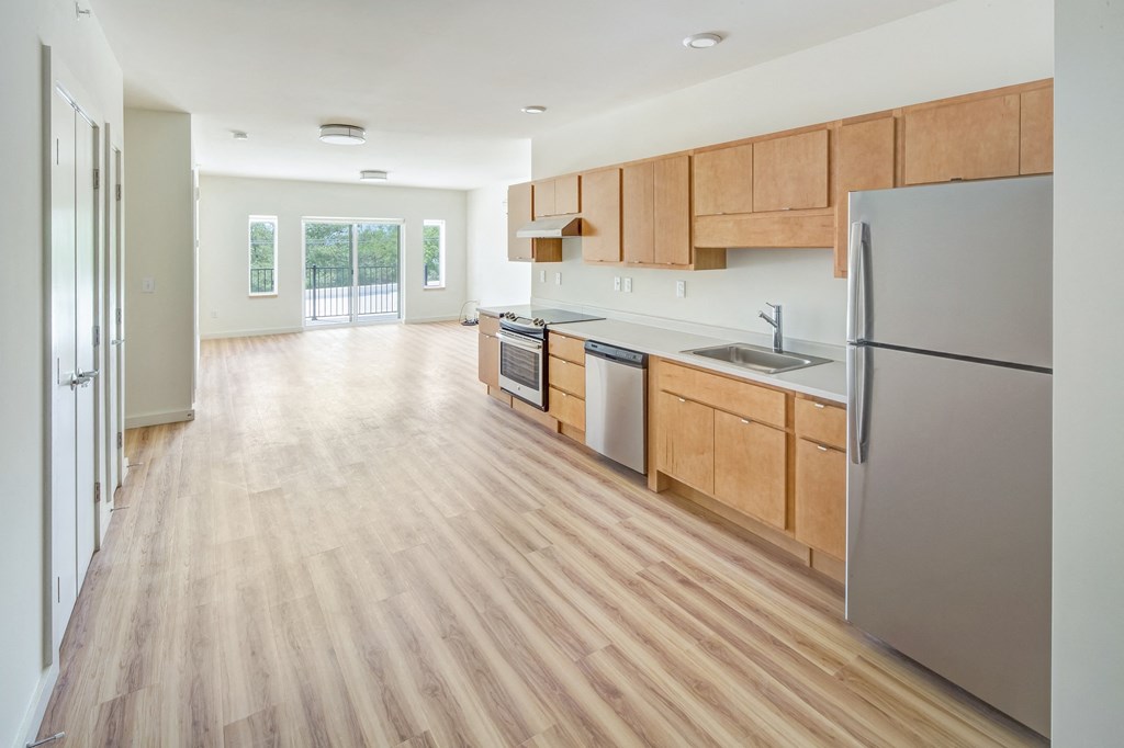 a large kitchen with wood flooring and stainless steel appliances