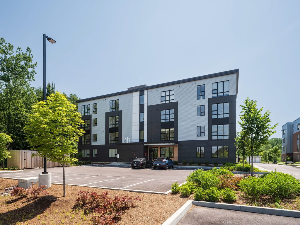 A modern building with a parking lot in front.