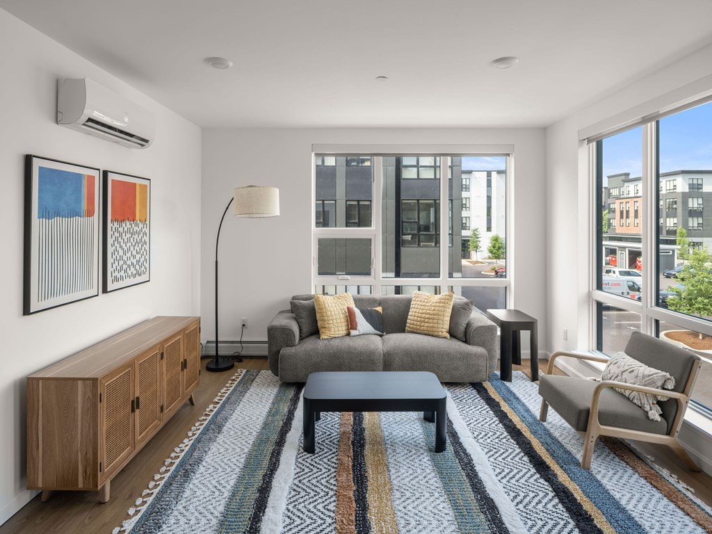 A living room with a grey couch and a wooden cabinet.