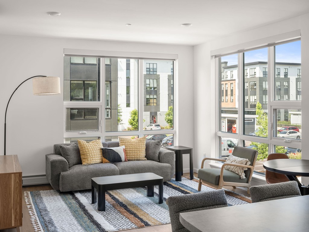 A modern living room with a grey sofa and a wooden side table.