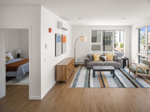 A modern living room with a grey sofa and a wooden sideboard.