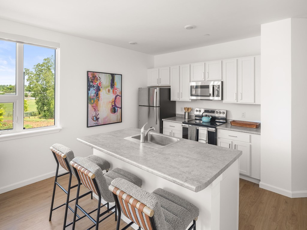 A kitchen with a bar area and a painting on the wall.