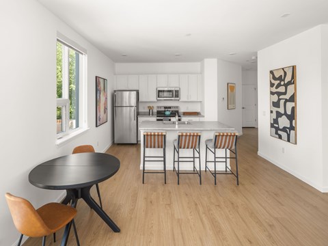 A modern kitchen with a dining table and chairs.