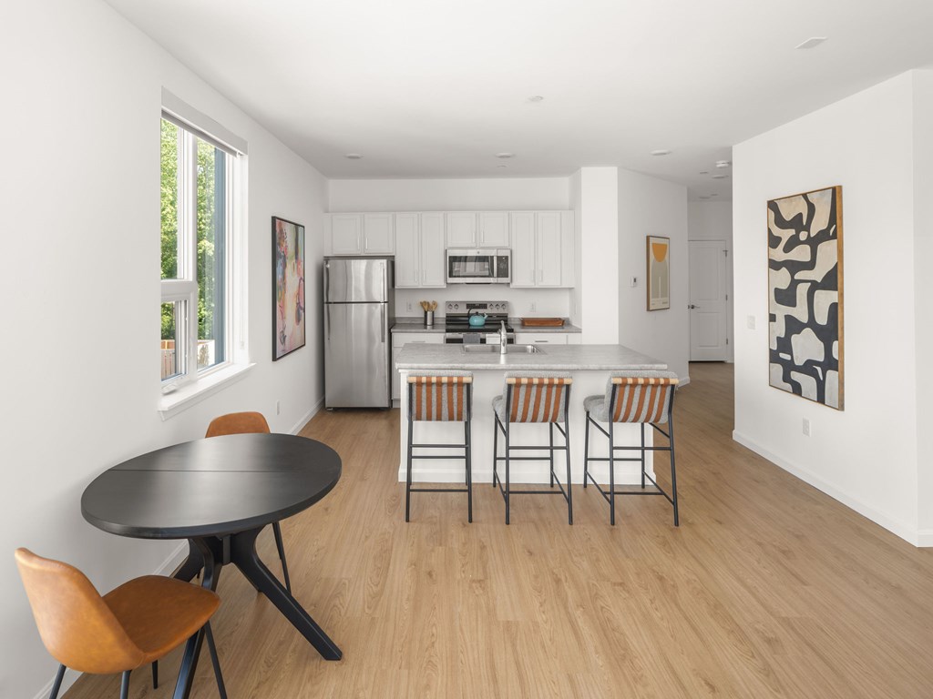 A modern kitchen with a dining table and chairs.