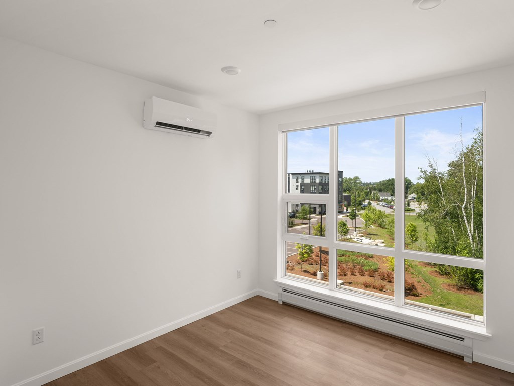 A room with a window overlooking a residential area.