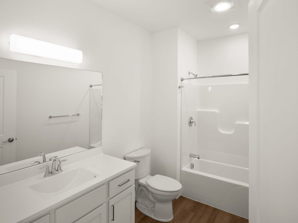 A white bathroom with a toilet, sink, and bathtub.