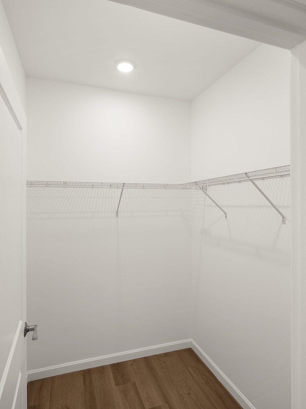 A white closet with a light on the ceiling.
