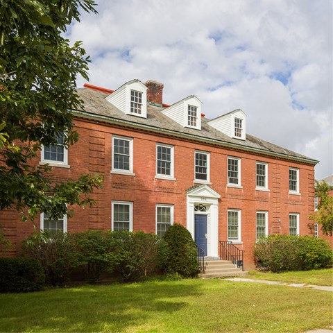 A red brick building with a white door and windows.
