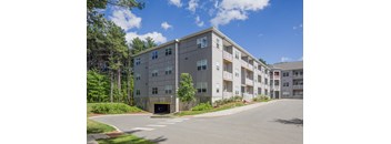 A large apartment complex with a parking lot in front.