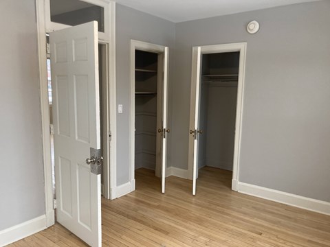 A room with a white door and two other doors with no windows.