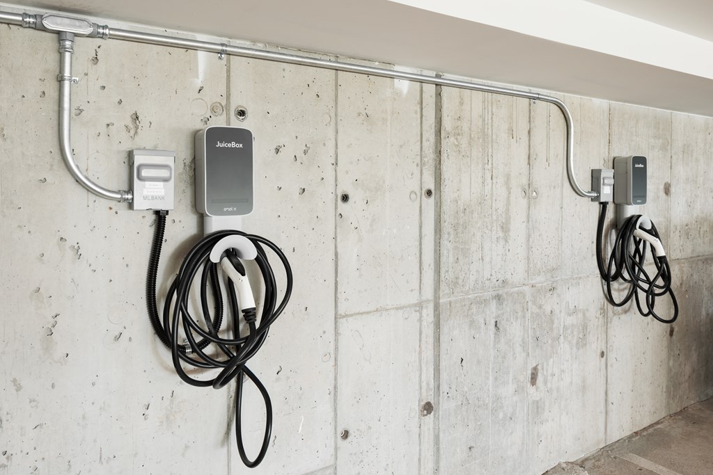 A wall with a charger and cables plugged into it.