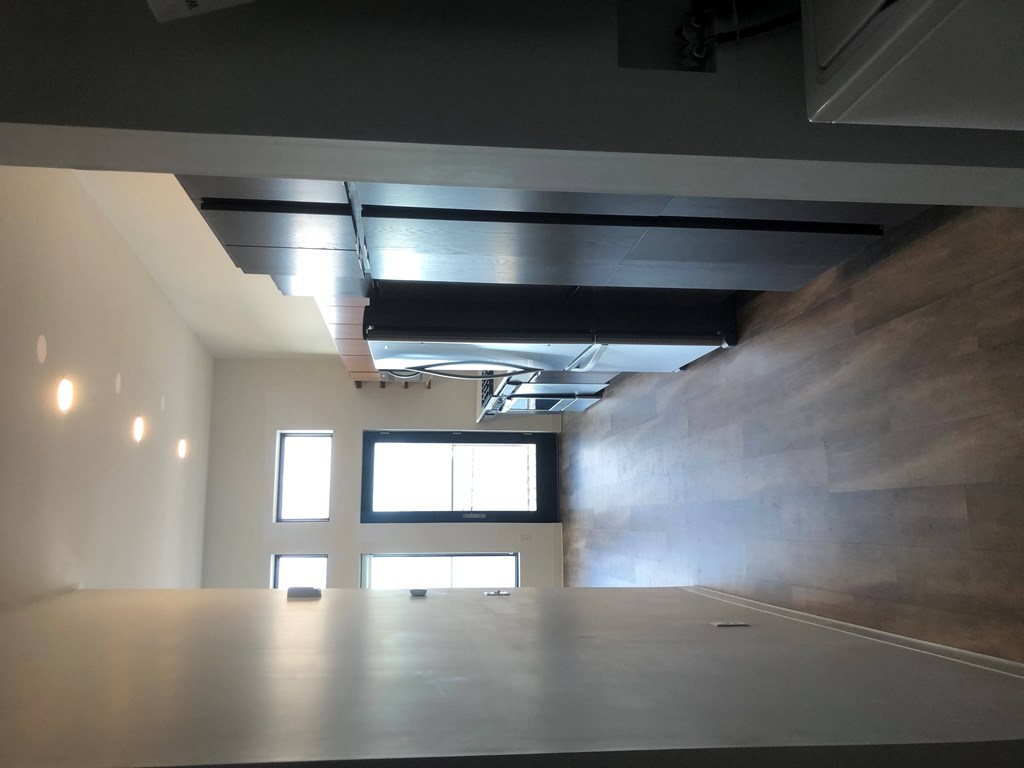 A room with a large window and a flat screen TV mounted on the wall.