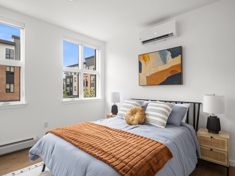 A bedroom with a large bed and a painting on the wall.