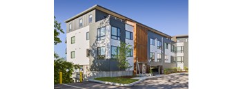 A modern building with a mix of grey and wood paneling.