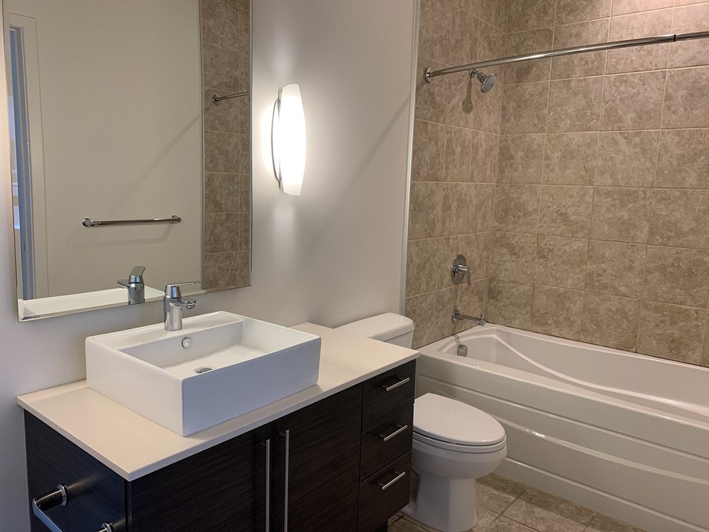 A bathroom with a sink, toilet, and bathtub.