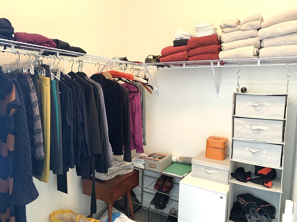 Clothes hanging on a rack in a room.