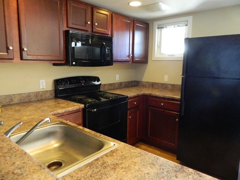 a kitchen with black appliances and granite counter tops