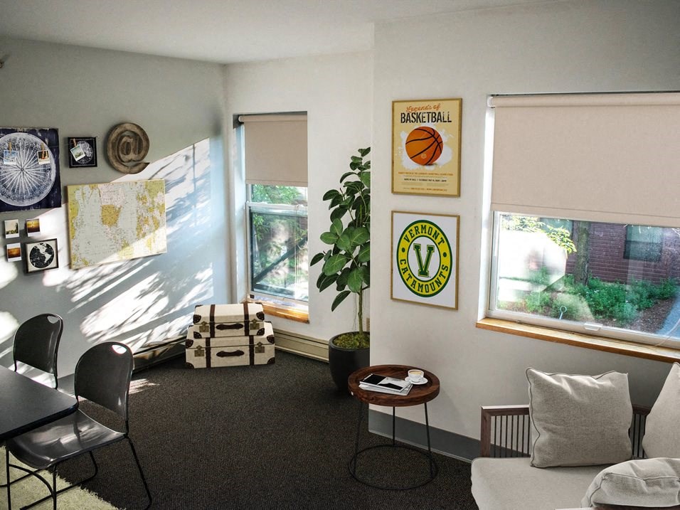 a living room with a table and chairs and a window