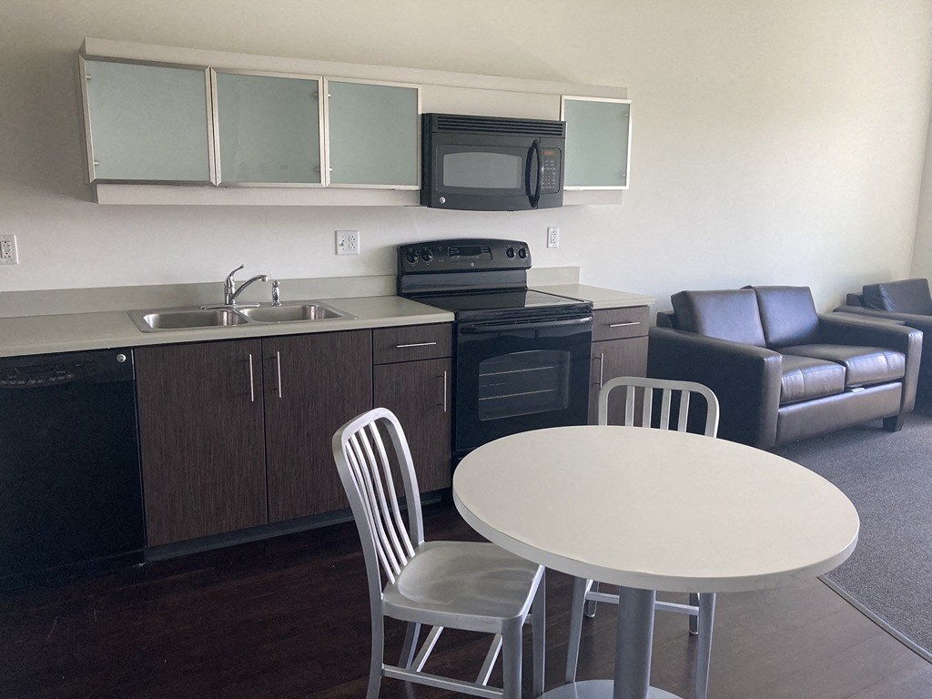 a small kitchen with a table and chairs and a living room with a couch