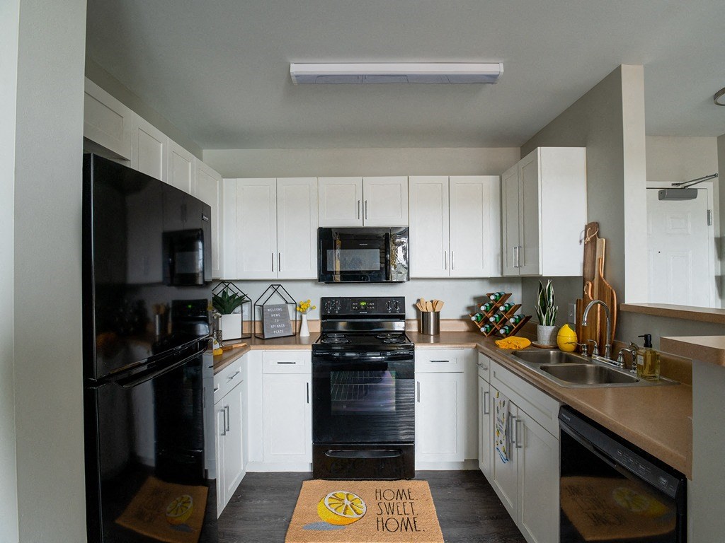 a kitchen with black appliances and white cabinets
