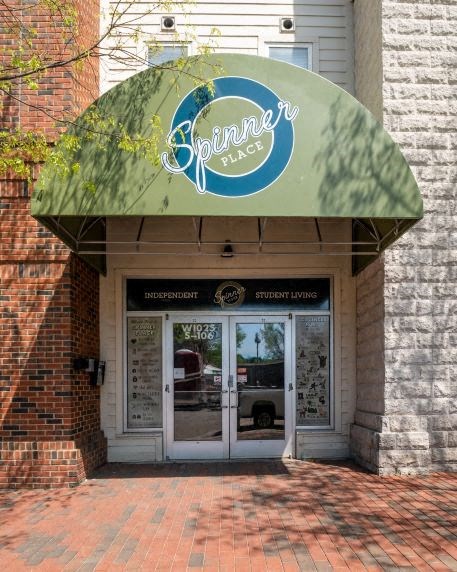 the front door of a building with a green awning