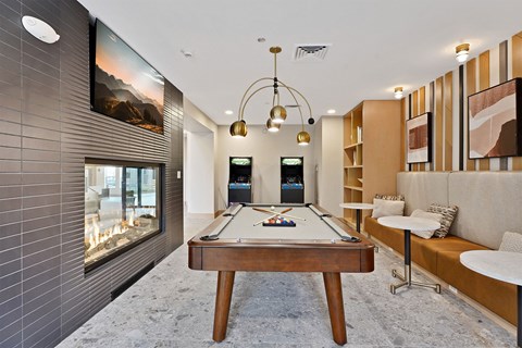 A pool table is in the middle of a room with a television and a couch.