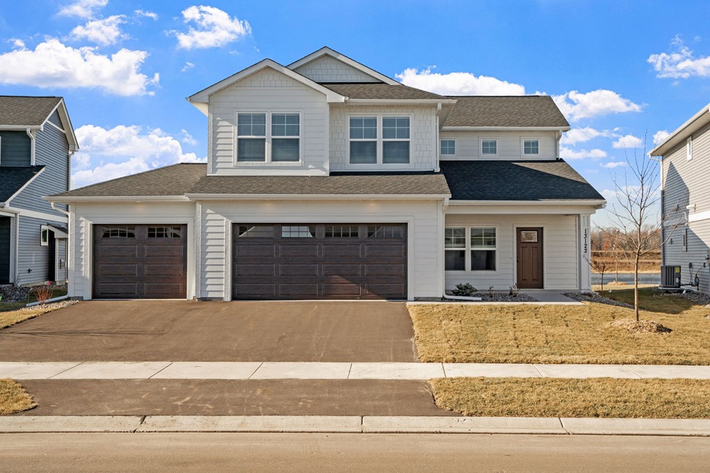 a white house with three car garage and a driveway