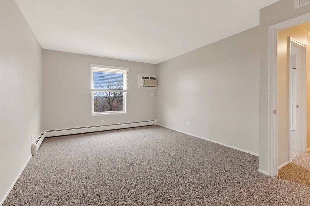 an empty room with carpet and a window