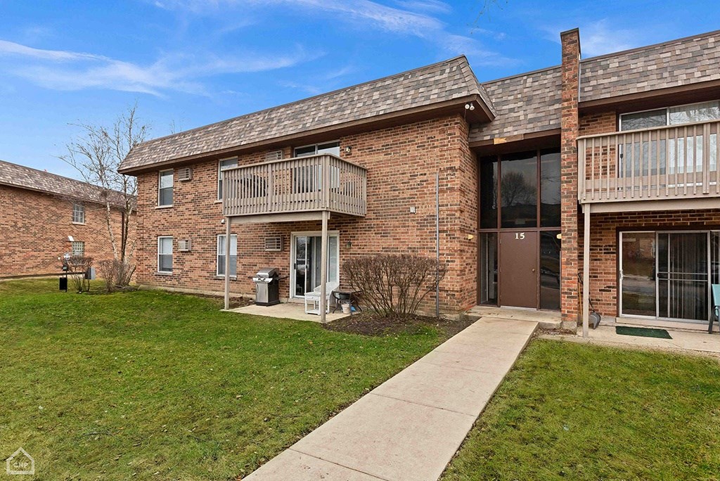 a brick apartment building with a sidewalk in front of it