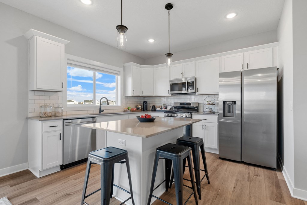 a large kitchen with a center island and three stools