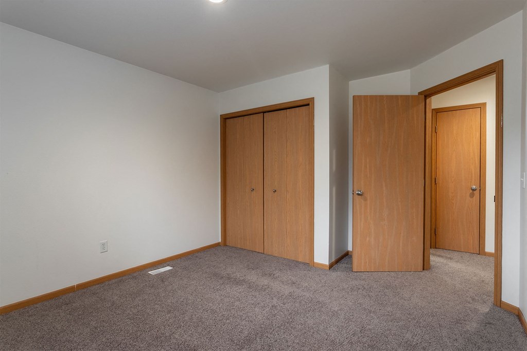 A room with two doors and a carpeted floor.