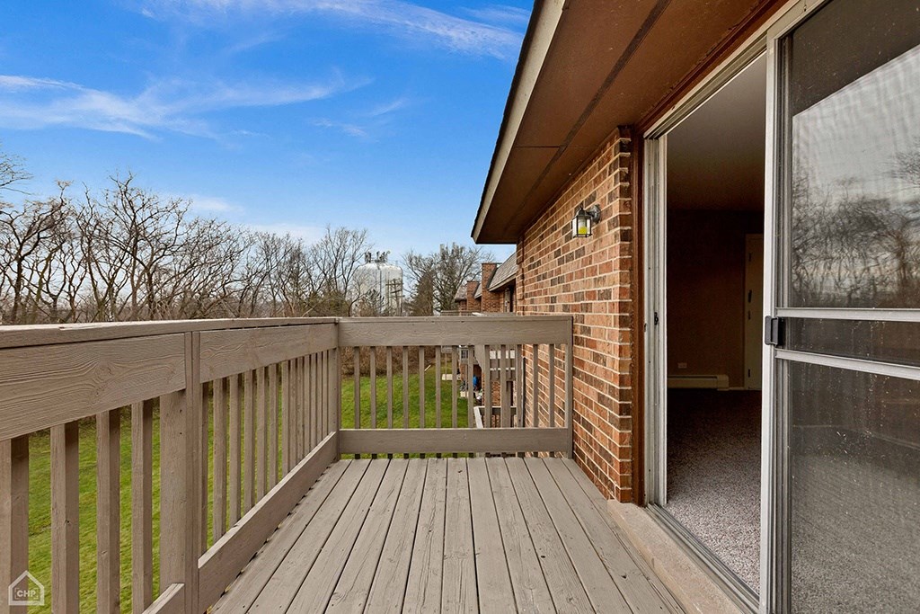 the deck of a home with a view of the yard and the sky