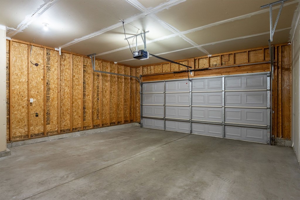 A garage with a white ceiling and a grey garage door.