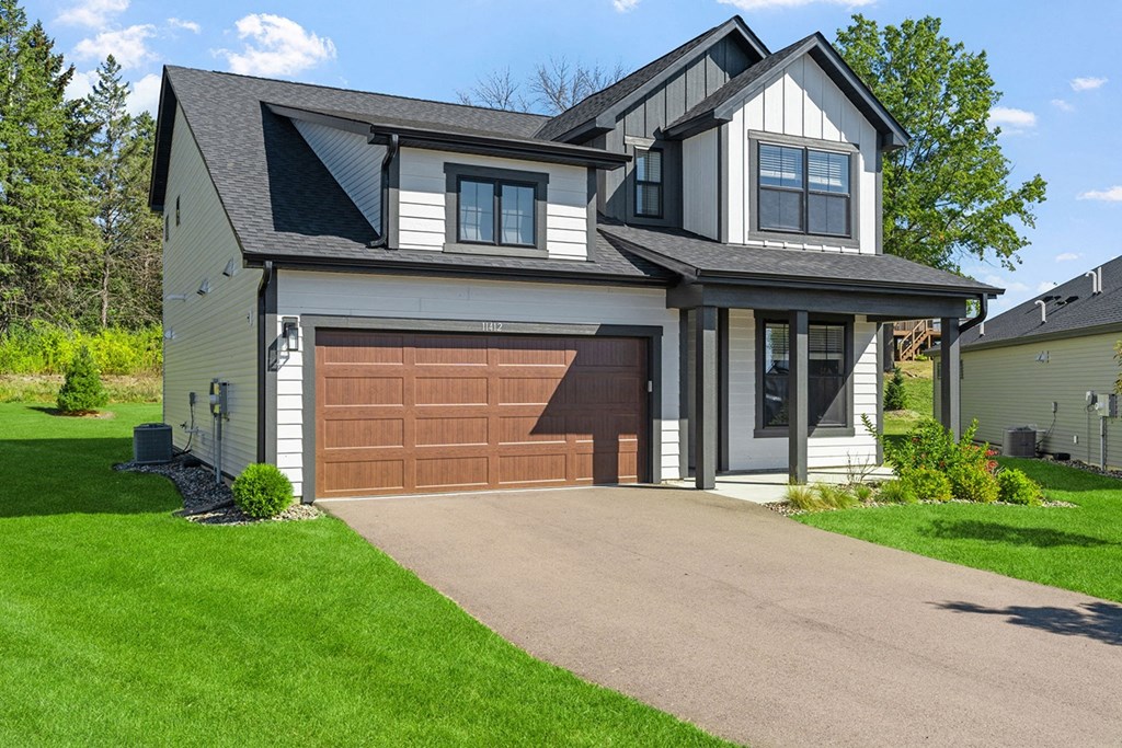 a house with a brown garage door in front of it
