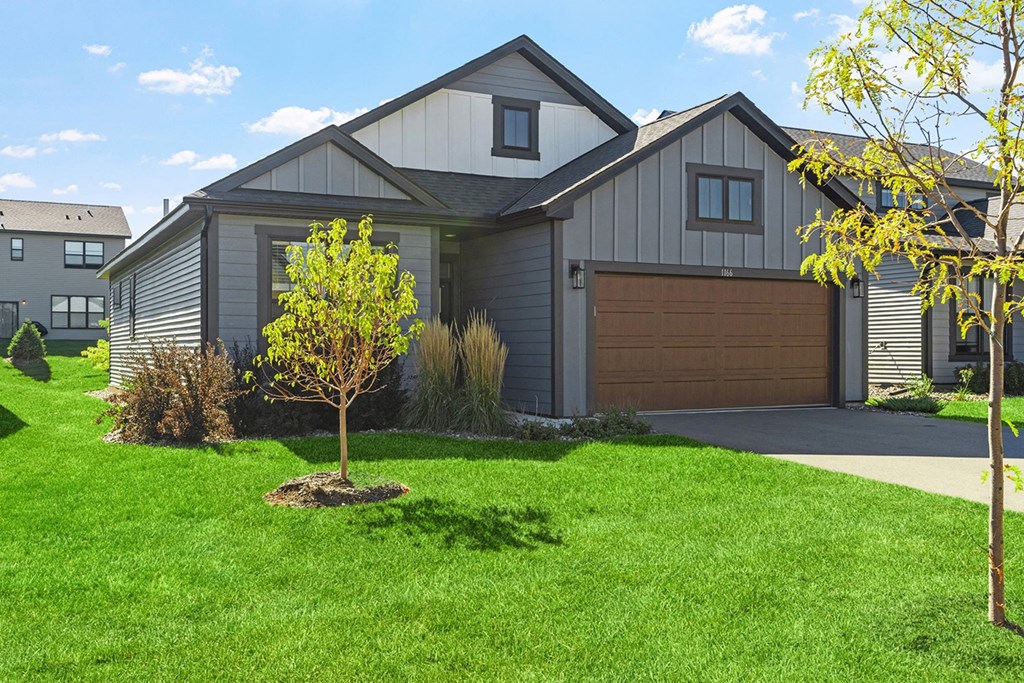 a home with a brown garage door and a green lawn