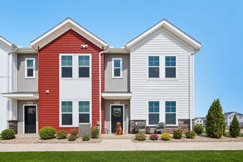 A red house is on the left and a white house is on the right.